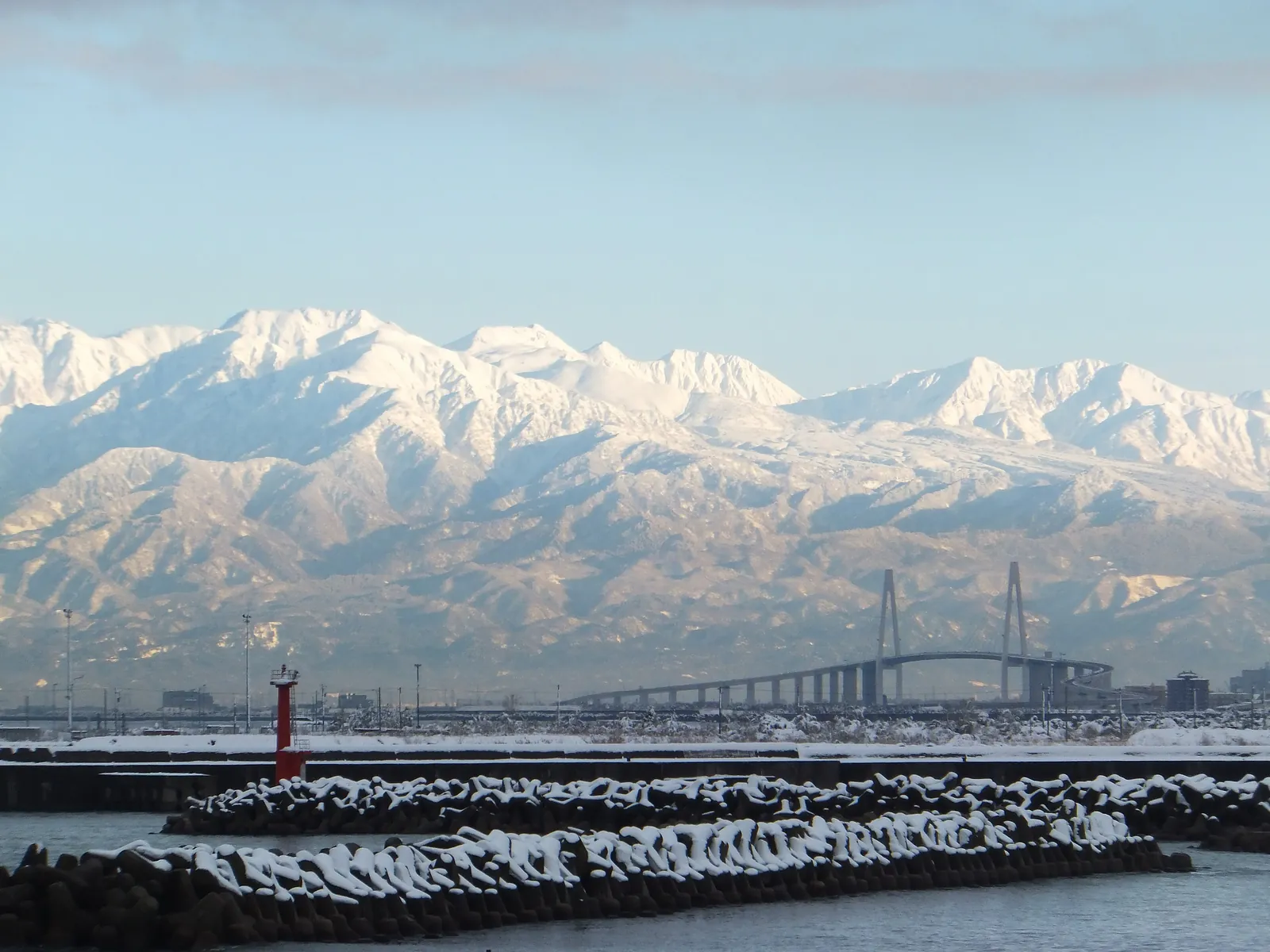 The Tateyama mountain range appearing across the water on a winter morning, with the Shinminato Bridge in the foreground. Photo: kiwa dokokano (CC BY-SA 3.0)