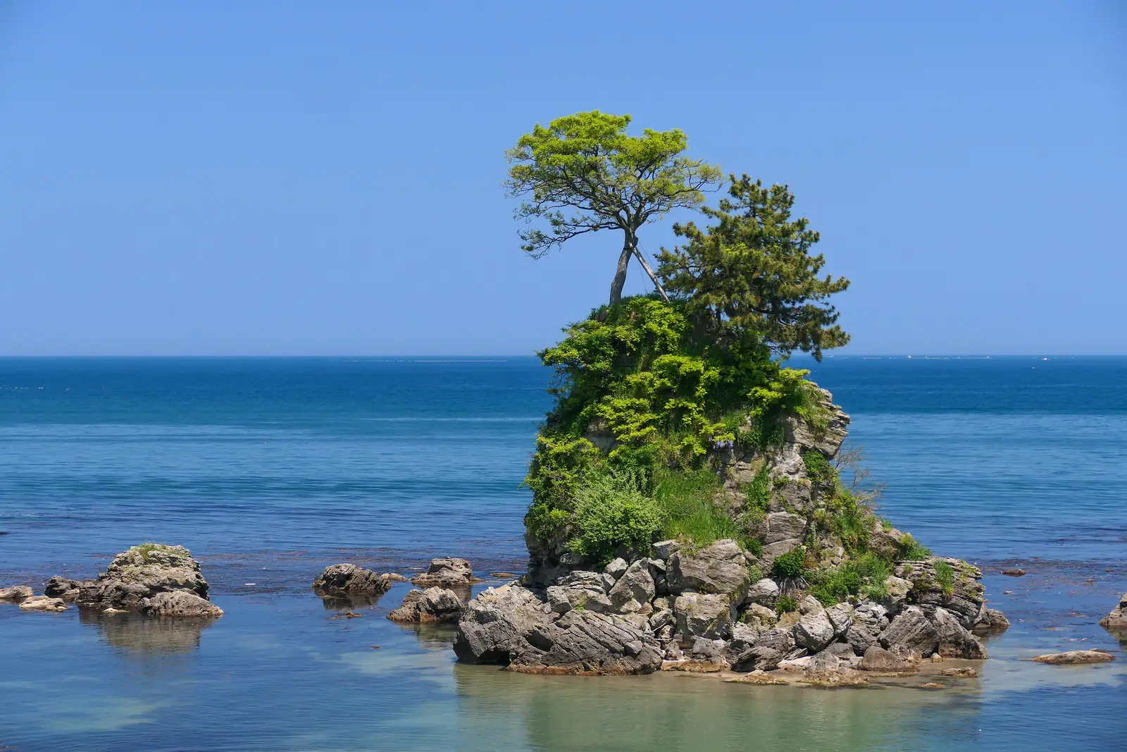 Onnaiwa rock on the Amaharashi Coast. On clear winter mornings, the Tateyama mountain range rises beyond this sea. Photo: MaedaAkihiko (CC BY-SA 4.0)