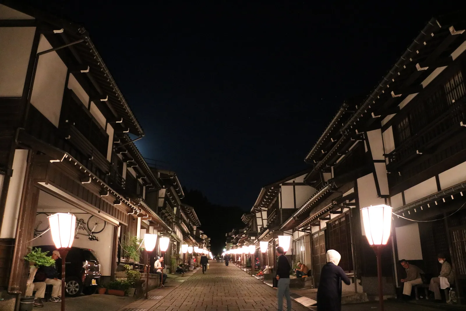 Suwamachi Street late at night, paper lanterns (bonbori) glowing far down the street. Photo: さかおり (CC BY-SA 4.0)