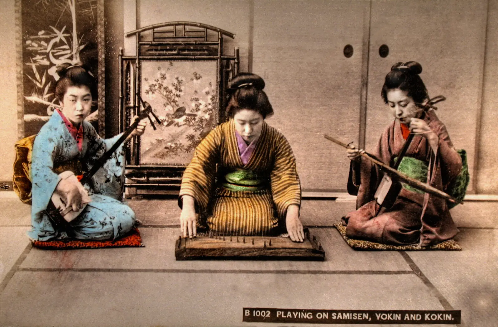 A sankyoku trio in a hand-colored Meiji-era photograph; at far right, the kokyu, played with a bow.