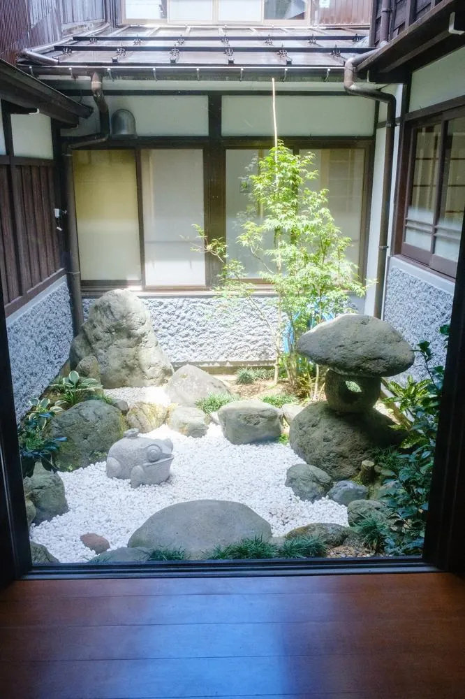 戸口の先の坪庭。奥まった部屋にも光と風を届ける仕掛け