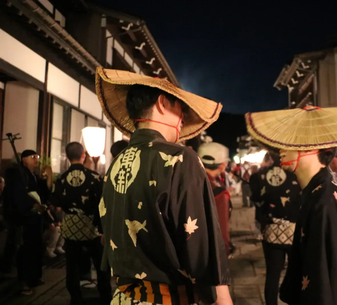 Suwamachi Street around midnight: dancers in amigasa (woven straw hats) return into the glow of the paper lanterns. Photo: さかおり (CC BY-SA 4.0)