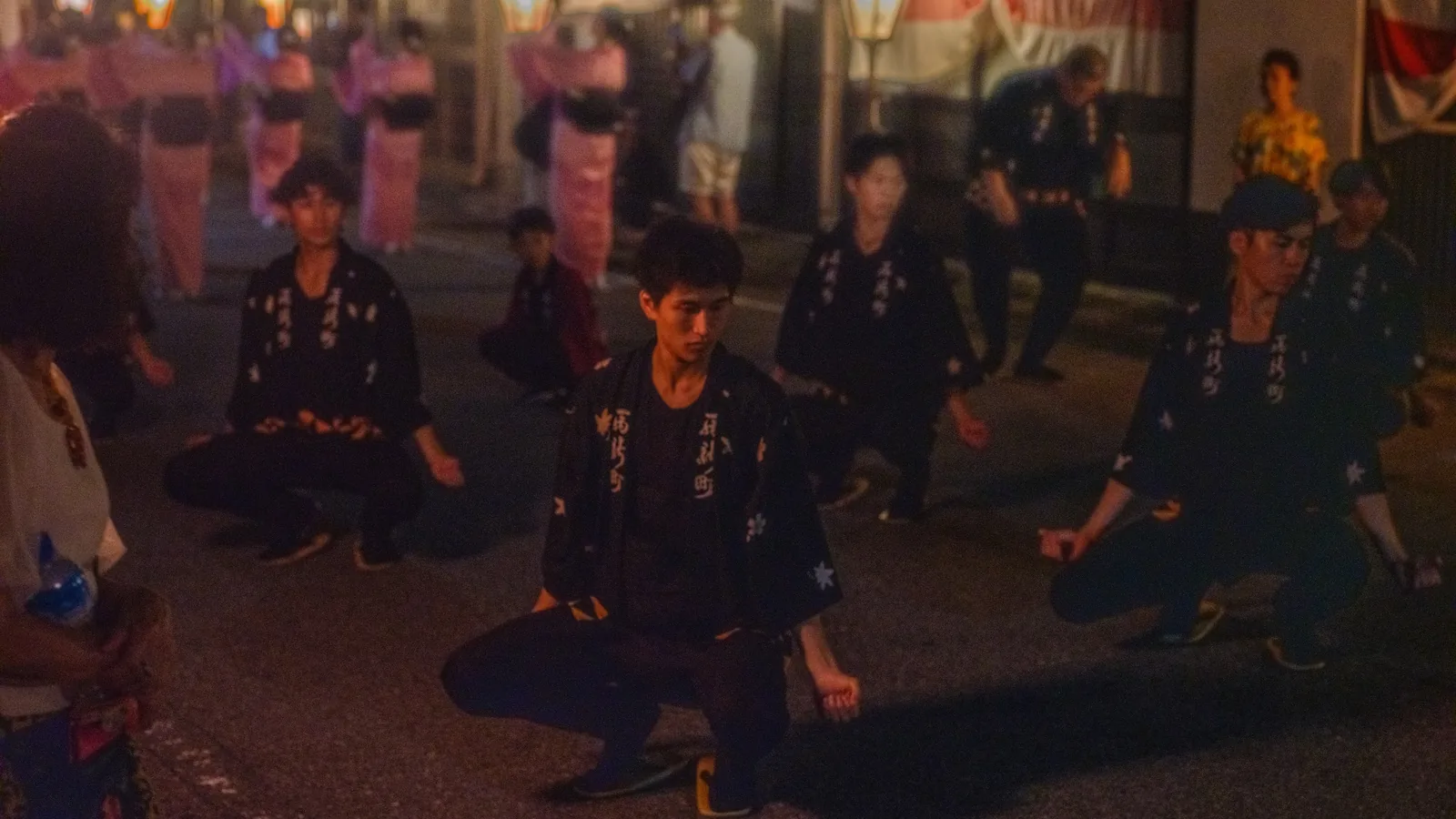 低く構える男踊り。日付が変わったあとの通りで