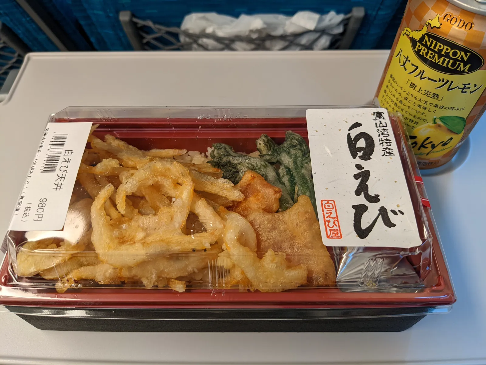 A bento topped with shiroebi kakiage fritters; the wrapper reads “Toyama Bay specialty.”