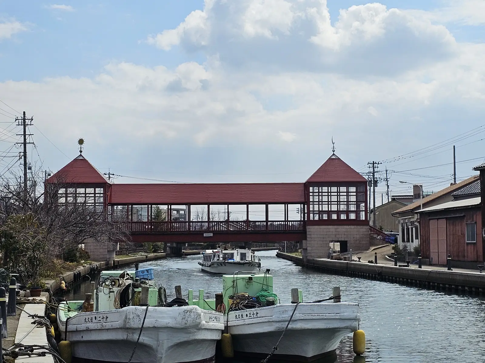 歩行者専用の屋根付き橋・東橋。手前の岸には漁船が並ぶ 写真: 漱石の猫(CC BY 4.0)